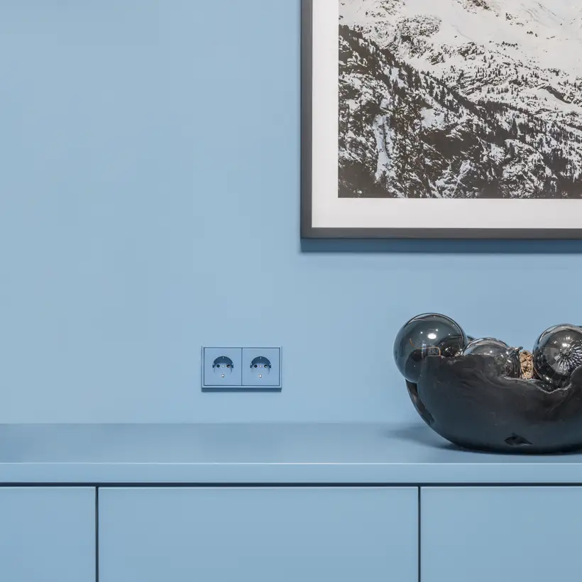 Blue JUNG LS 990 sockets on a blue wall in a Stuttgart clinic