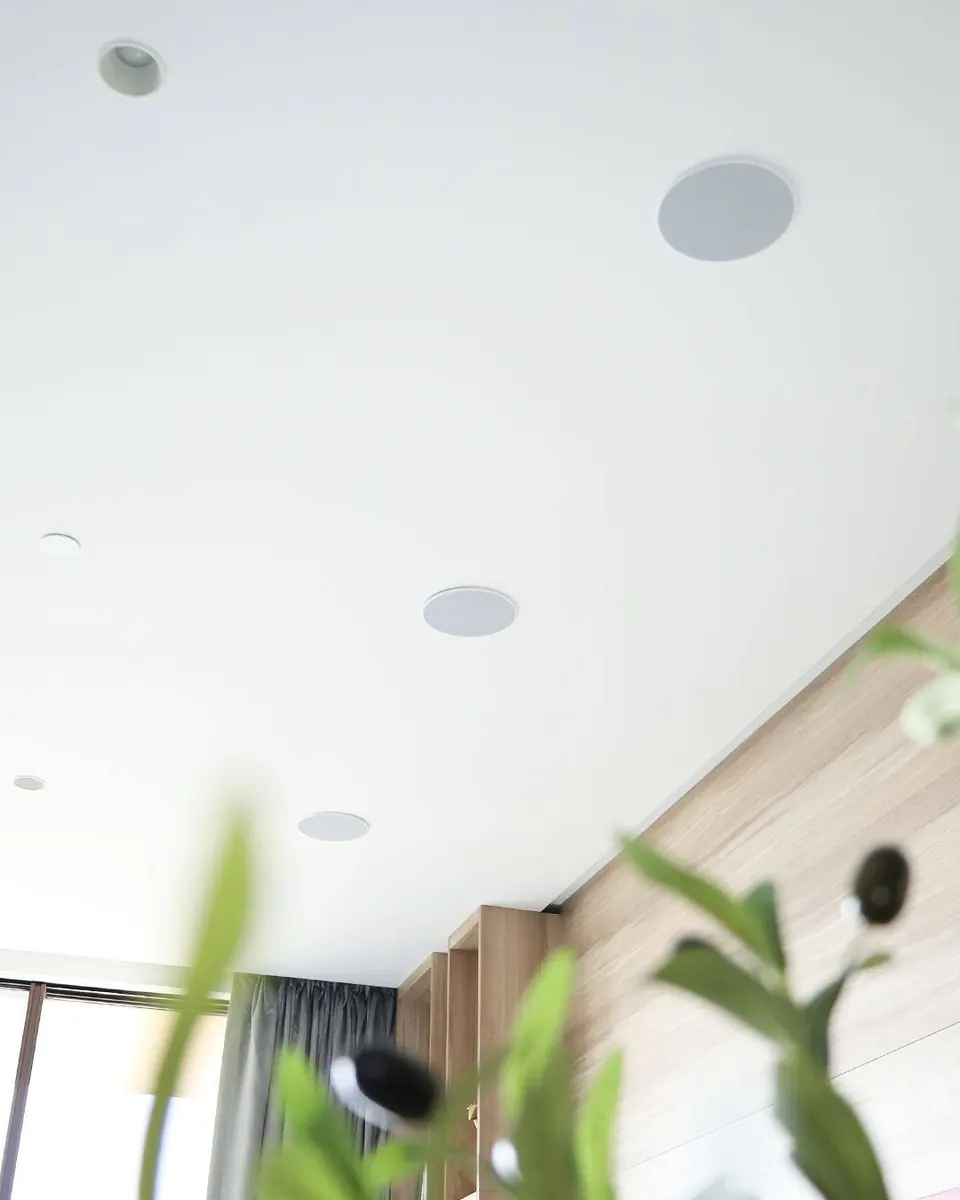 In-ceiling Artsound speakers in an Atlantis apartment living area ceiling with greenery in foreground