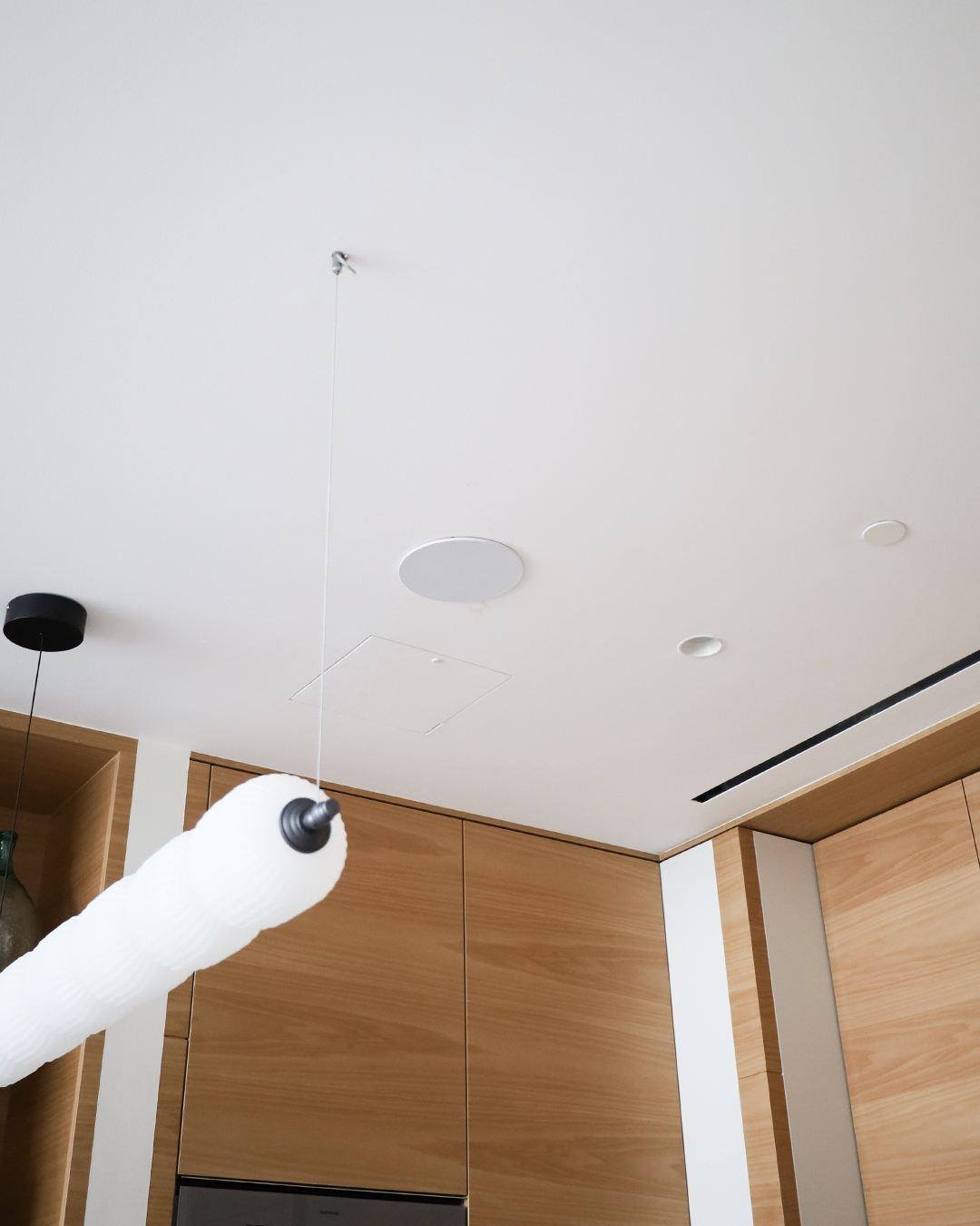 In-ceiling Artsound speaker in an Atlantis apartment kitchen ceiling next to a pendant light
