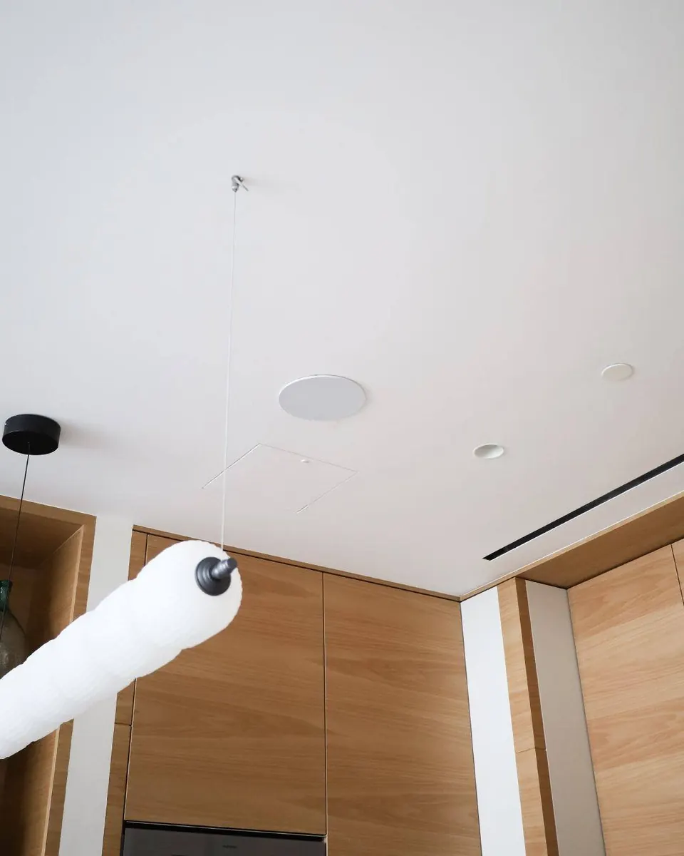 In-ceiling Artsound speaker in an Atlantis apartment kitchen ceiling next to a pendant light