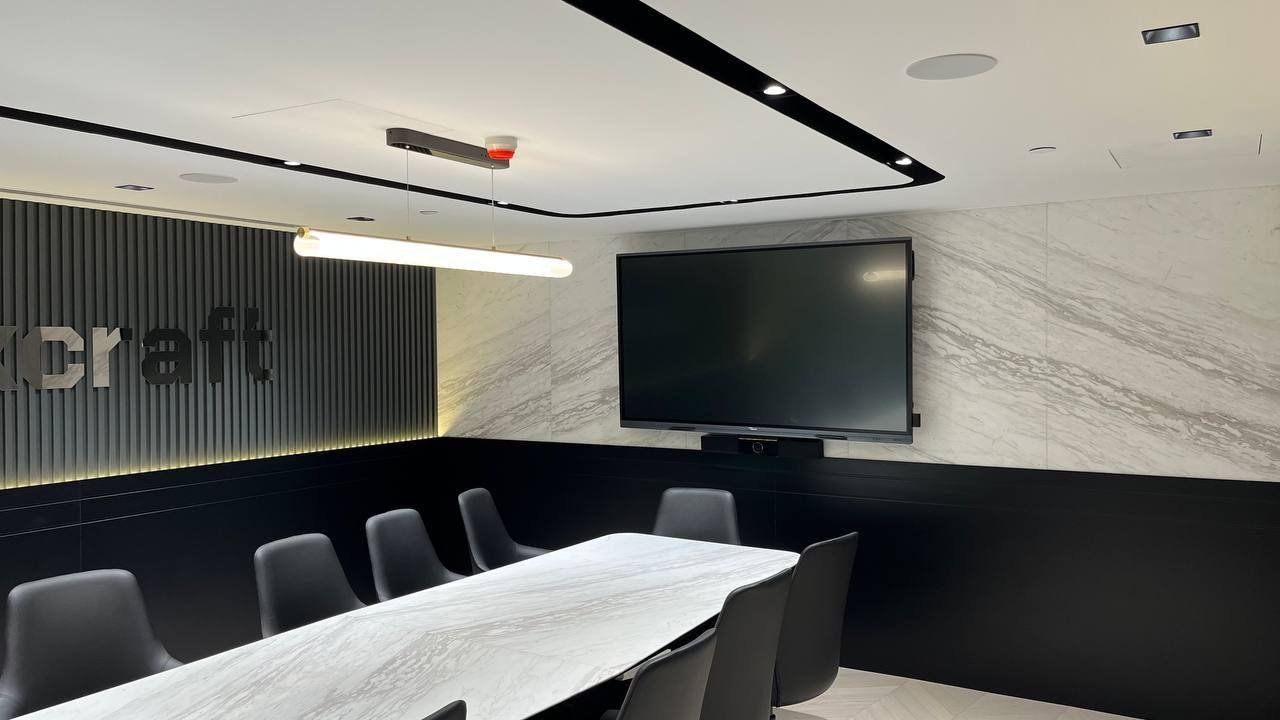In-ceiling Artsound speakers in a Downtown Dubai office boardroom with marble table and wall-mounted display