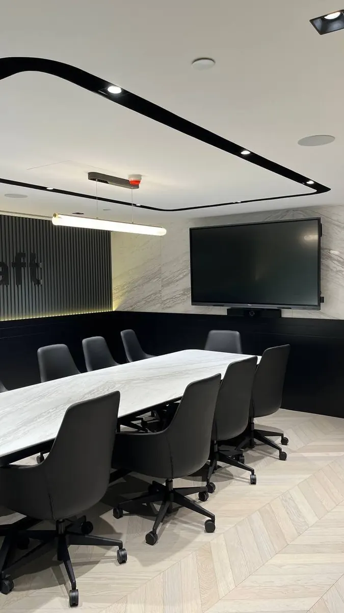 Downtown Dubai office boardroom with in-ceiling speaker, chairs and wall-mounted screen