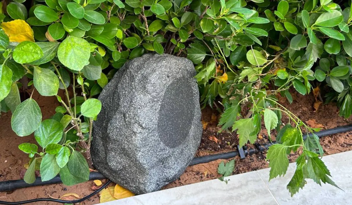 Artsound ROCKS faux-stone outdoor speaker tucked into garden landscaping